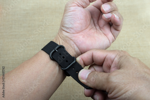 Adjusting watch strap to fit for wrist.