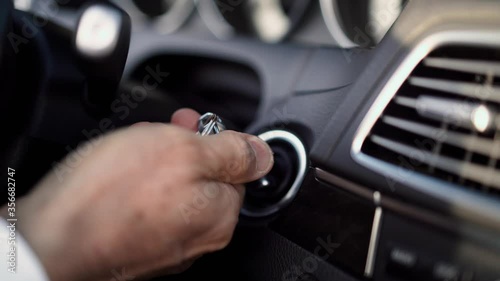 Men's hand turns key in ignition car start