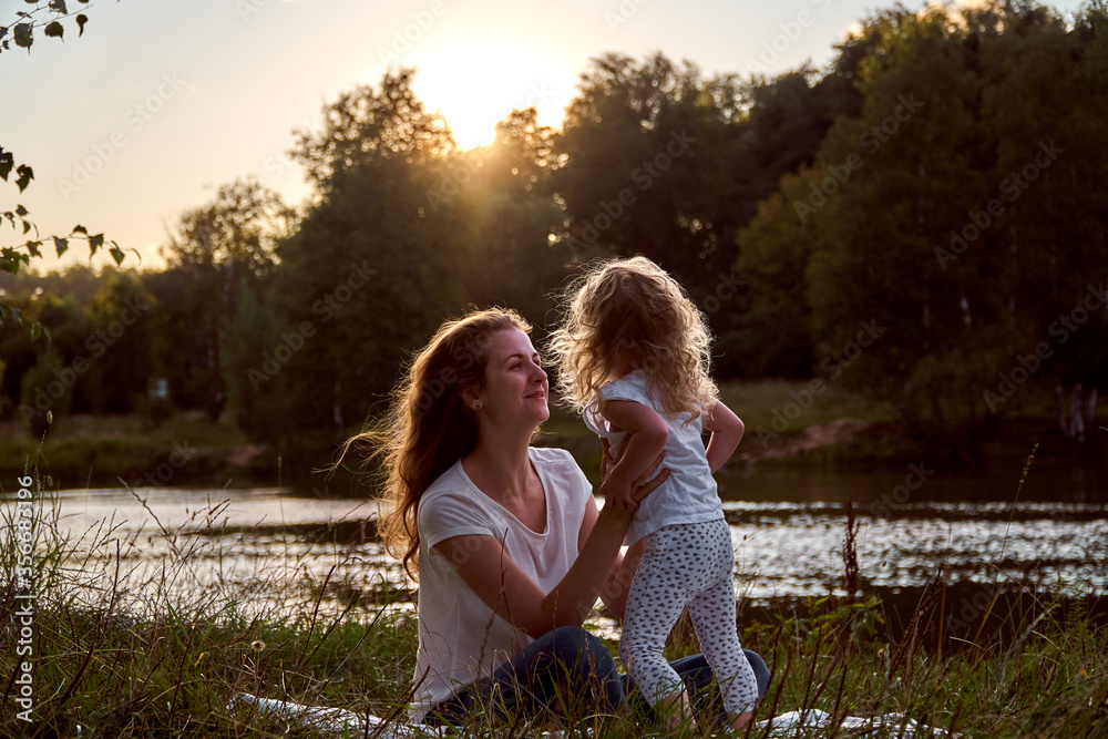 Daughter and mom are hands together. The family is happy. Smiles and laughter. They look at each other. Daughter and mom are hands together. The family is happy. Smiles and laughter. They look at each other.