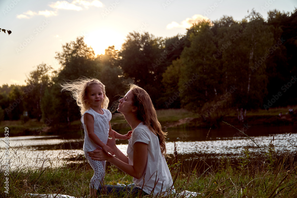 Fototapeta premium Daughter and mom are hands together. The family is happy. Smiles and laughter. They look at each other.