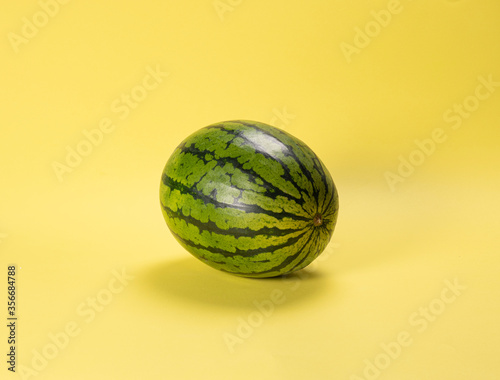 green watermelon on yellow background