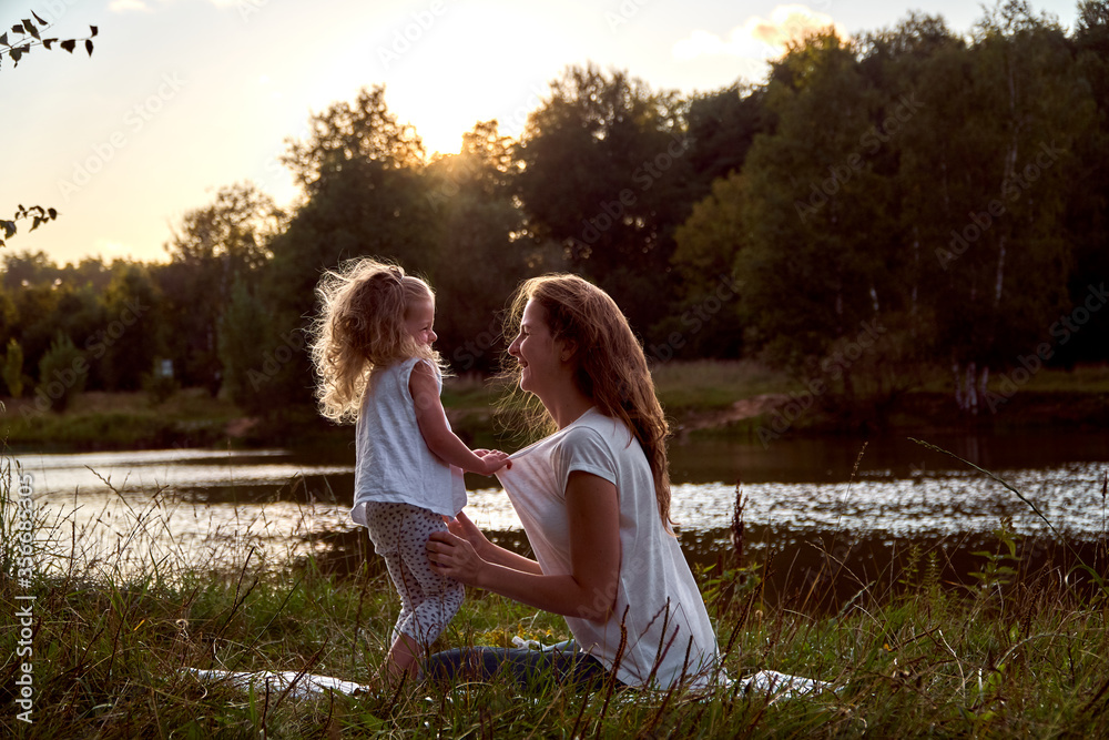 Daughter and mom are hands together. The family is happy. Smiles and laughter. They look at each other. Daughter and mom are hands together. The family is happy. Smiles and laughter. They look at each other.