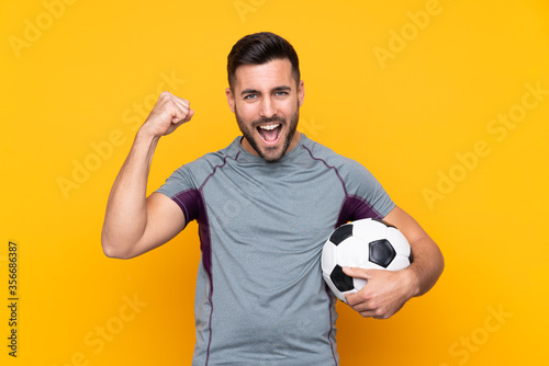 Football player man over isolated background celebrating a victory