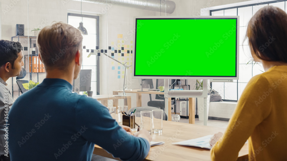 Team of Entrepreneurs Have a Meeting and Watch Green Screen Interactive Whiteboard. Young People Work in Creative Office. - obrazy, fototapety, plakaty 