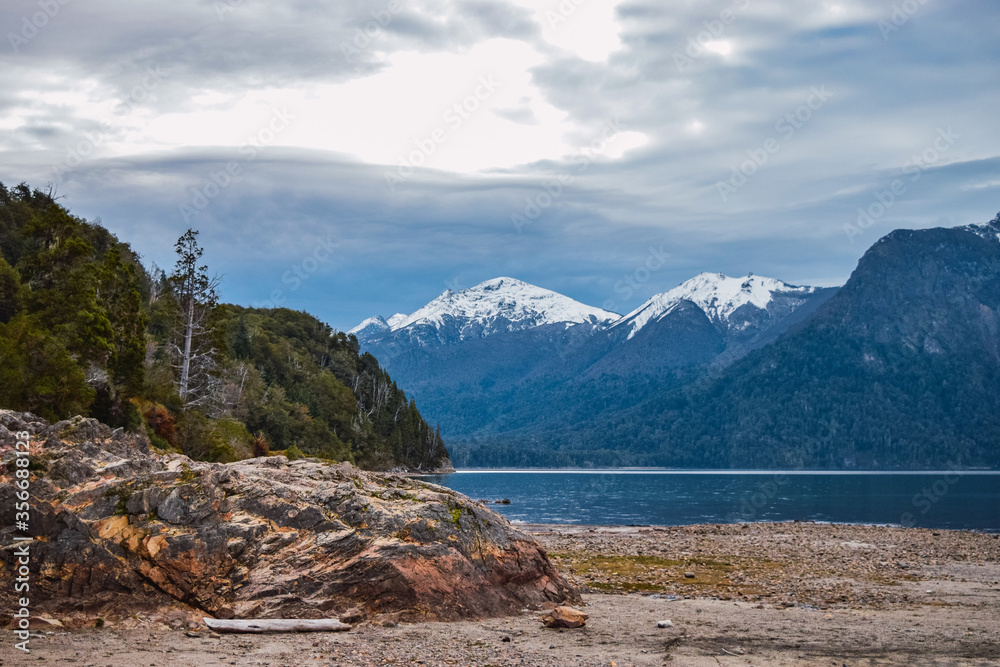 Obraz premium Patagonia lake with snowy mountains and pine forests