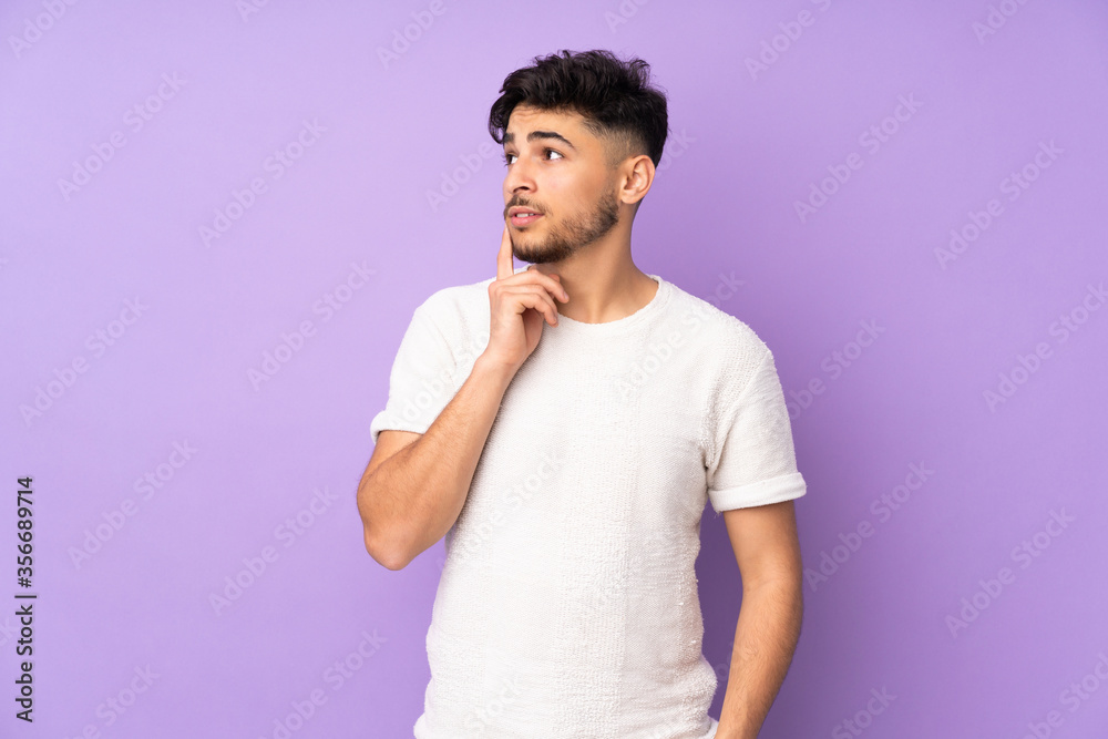 Obraz premium Arabian handsome man over isolated background thinking an idea while looking up