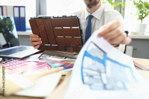 Photography Close-up of business worker choosing proper colour of paint for room wall