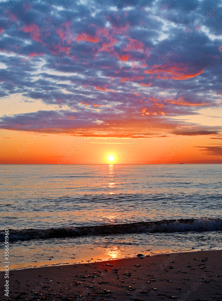 Great sunset at sea. Light waves, heavy clouds. Colorful sunset. The hot sun falls below the sea horizon. The clouds are especially relievo. Great sunset at sea. Light waves, heavy clouds. Colorful sunset. The hot sun falls below the sea horizon. The clouds are especially relievo.