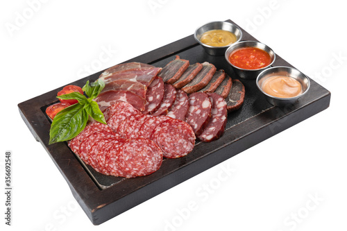 assorted smoked meats, salami sausages on a board on a white background 