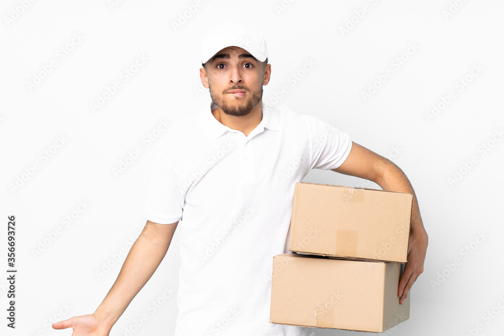 Delivery Arabian man isolated on blue background having doubts and with confuse face expression Delivery Arabian man isolated on blue background having doubts and with confuse face expression