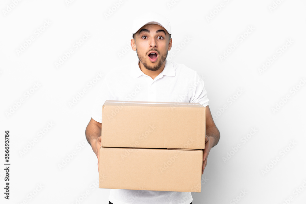 Delivery Arabian man isolated on blue background with surprise facial expression Delivery Arabian man isolated on blue background with surprise facial expression