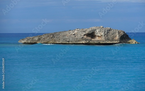 Beautiful rock island n the middle of turquoise blue waters in a tropical island