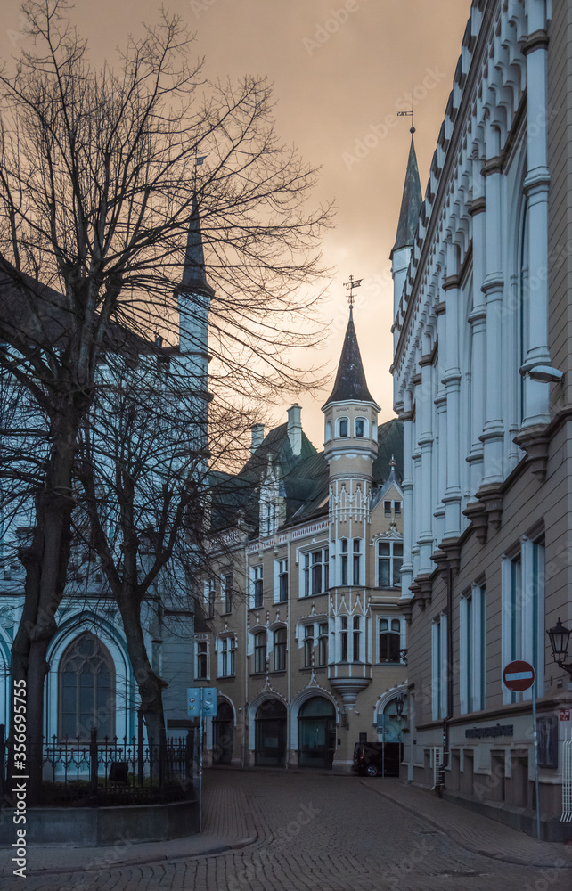 View to the empty Amatu street with Small Guild and the Great Guild on the corner in the Old Town of Riga in early spring evening
