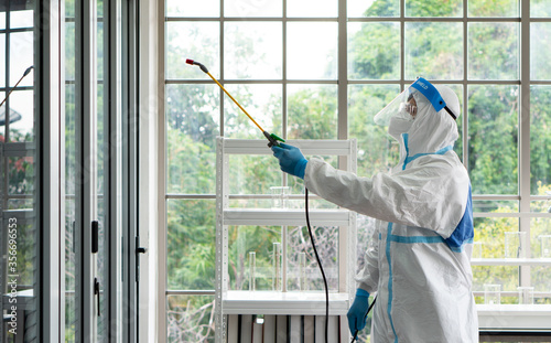 Wallpaper Mural worker from decontamination services wearing personal protective equipment or ppe including suit, face shield and mask. He uses disinfectant to spray and clean scientist lab Torontodigital.ca