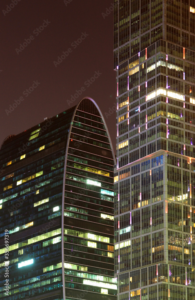 Close up of modern skyscraper illuminated at night Close up of modern skyscraper illuminated at night