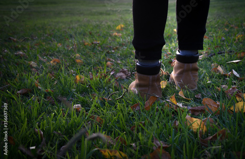 girl steps on the grass at sunset photo