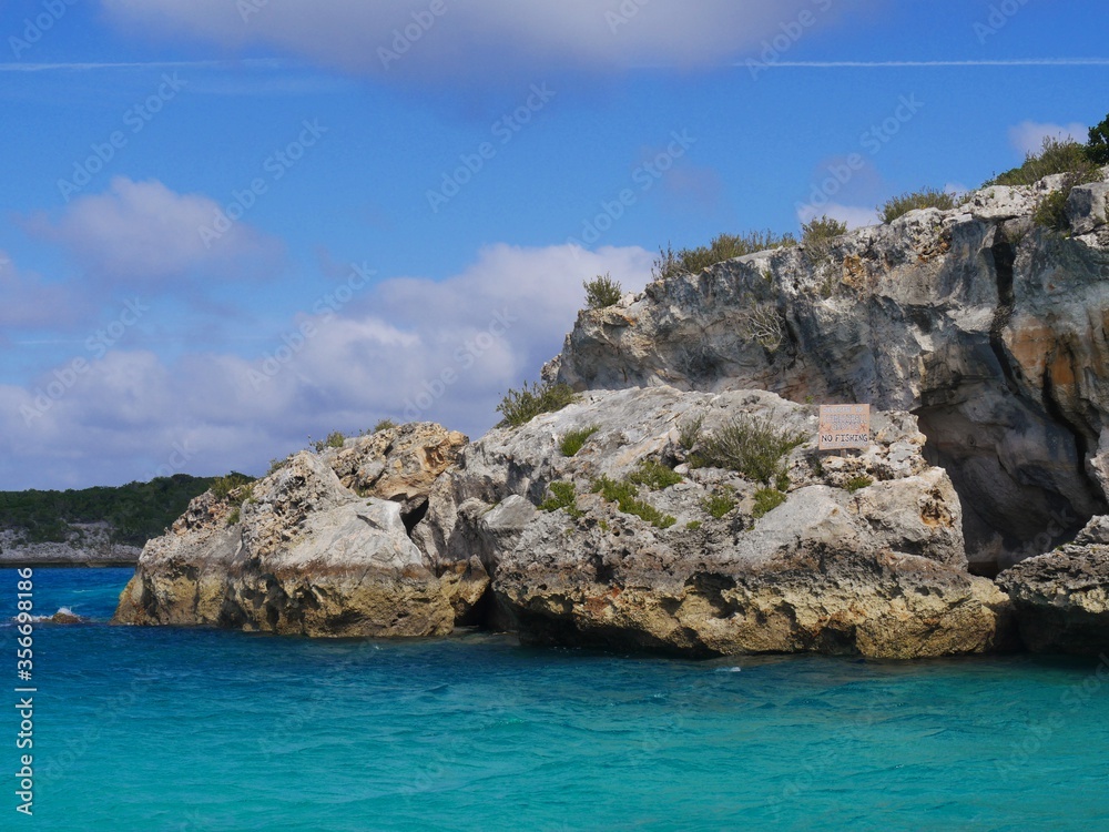 Boulders of rocks hiding the Thunderball Grotto in the blue waters of Exuma Cays, Bahamas. The location is a popular destination and has been used for filming several movies.