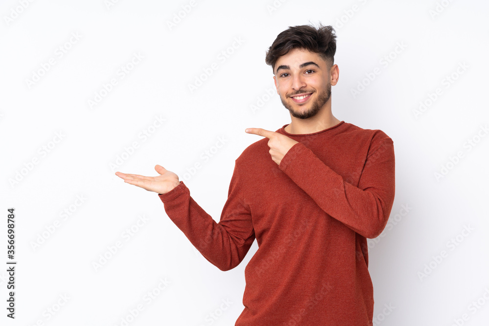 Arabian handsome man over isolated background holding copyspace imaginary on the palm to insert an ad Arabian handsome man over isolated background holding copyspace imaginary on the palm to insert an ad