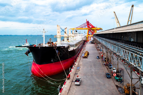 Large bulk cargo berthing at port discharging cargo. 