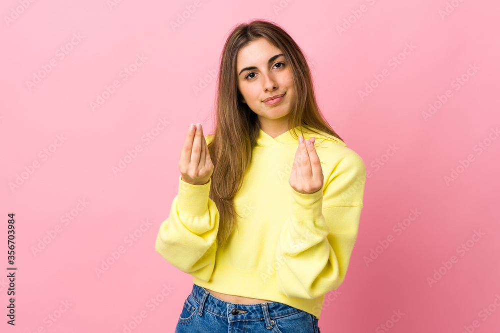 Young woman over isolated pink background making money gesture but is ruined Young woman over isolated pink background making money gesture but is ruined