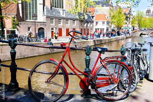 Vintage red bicycle tied up near an canal in Amsterdam, Netherlands