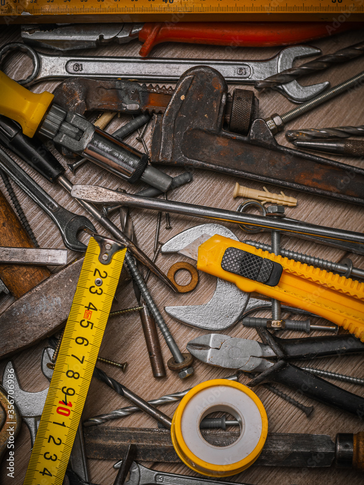 Building and measuring tools. Set of tools over a wood panel. Construction Tools With Blueprint On Wooden Desk Building and measuring tools. Set of tools over a wood panel. Construction Tools With Blueprint On Wooden Desk