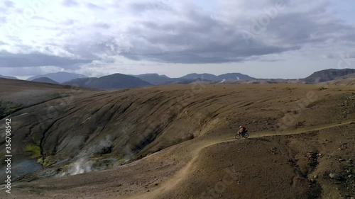 Amazing aerial drone shot of people riding on a path in Iceland