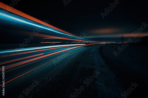 Long exposure of a road with light trails of passing vehicles, glowing sky photo