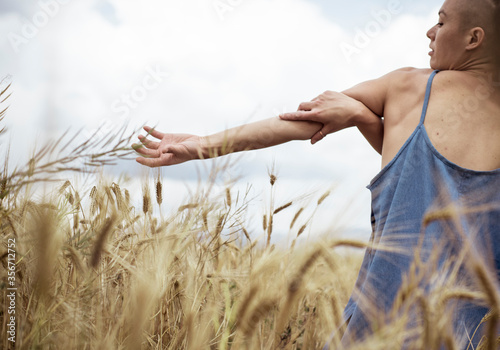 Fotografie Rear view hipster female practicing contemporary dance in farm against sky