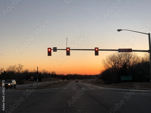 NORMAN, OKLAHOMA--JANUARY 2018: Traffic light in a road intersection at sunset.