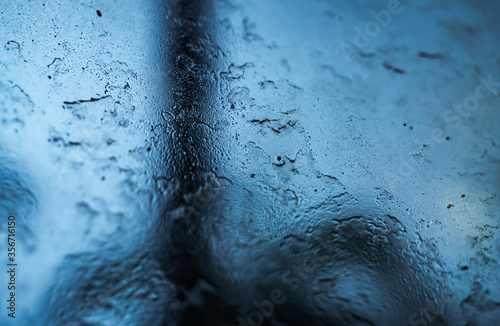 Macro photography of a window blurred and wet by raindrops, perfect combination for nostalgia