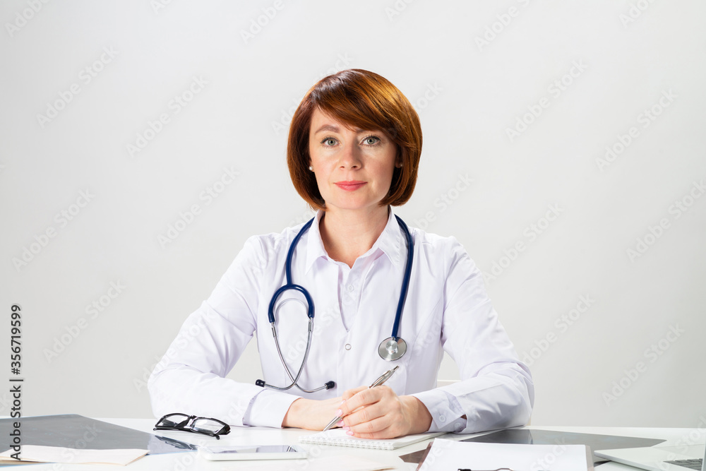 Beautiful doctor sitting in office and writing Beautiful doctor sitting in office and writing