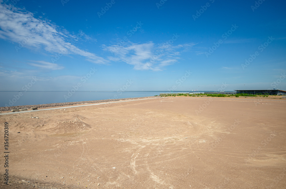 Construction of a residential complex by the sea. The progress of construction of the residential complex Morskaya embankment. Houses in the sand by the water. Russia, St. Petersburg, June 9, 2020