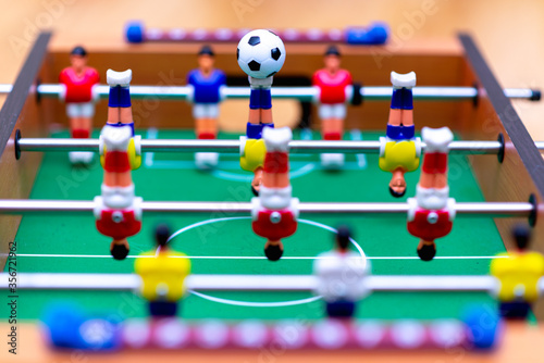 Close up table soccer with players and a ball.