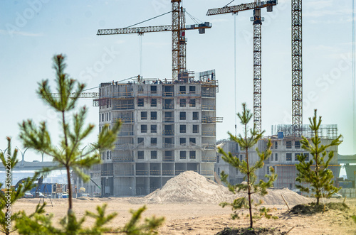 Construction of a residential complex by the sea. The progress of construction of the residential complex Morskaya embankment. Houses in the sand by the water. Russia, St. Petersburg, June 9, 2020 photo