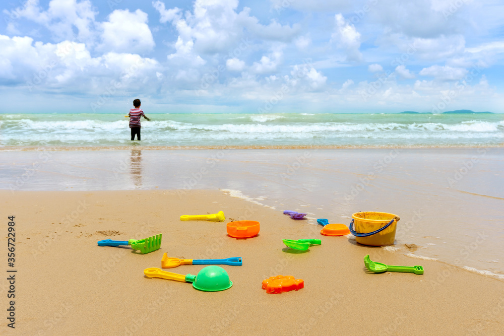 Little asian boy play with sand on the beach.Many colorful sand toy and Little asian boy play with on the sea. Little asian boy play with sand on the beach.Many colorful sand toy and Little asian boy play with on the sea.