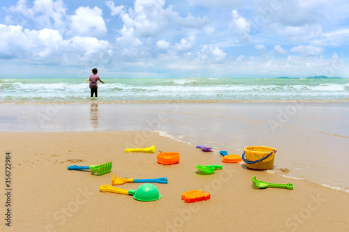 Little asian boy play with sand on the beach.Many colorful sand toy and Little asian boy play with on the sea.