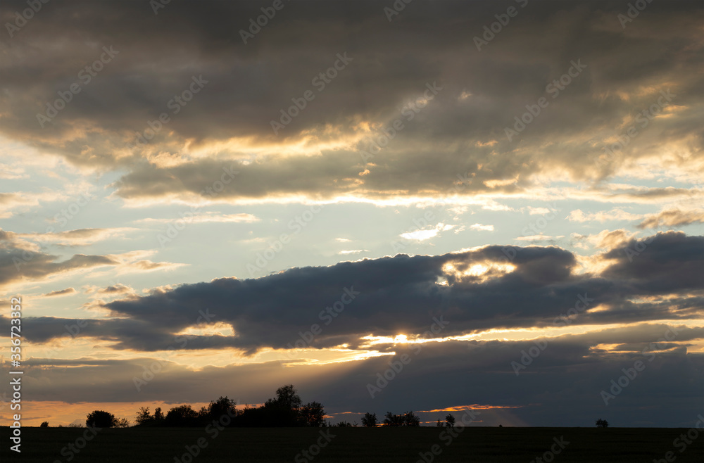 Landscape at sunset. Tragic gloomy sky. The village in the Budjak steppe. The terrain in southern Europe. Panorama.