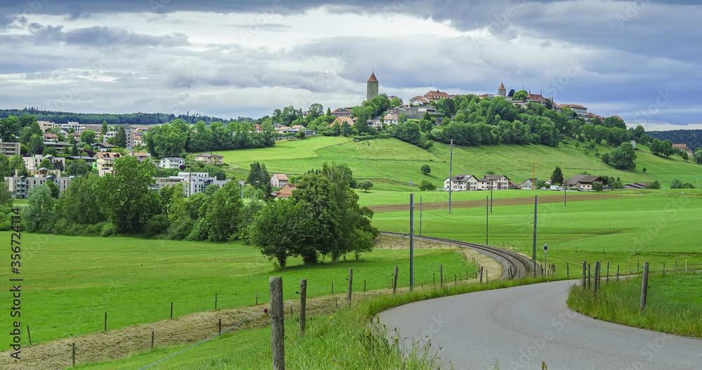 Timelapse de nuages noirs qui défilent au-dessus de la cité médiévale de Romont dans le canton de Fribourg avec des trains qui passent