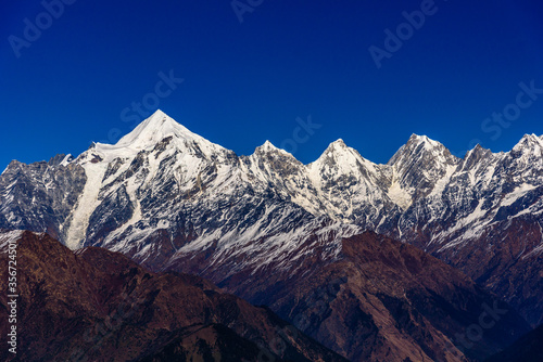 View of Snow cladded Panchchuli peaks falls in great Himalayan mountain range    alpine grass meadows enroute to Khalia Top trekk trail at small hamlet Munsiyari  Kumaon region  Uttarakhand  India.