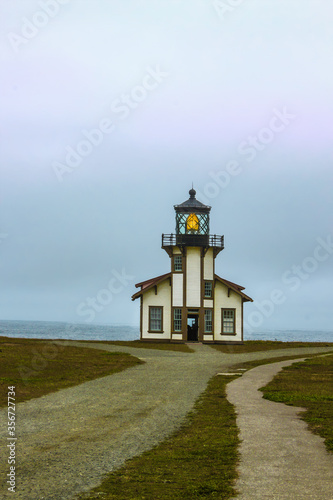 Point Cabrillo Lighthouse north of Mendicino California with tourists walking around and looking out over the ocean on a foggy day photo