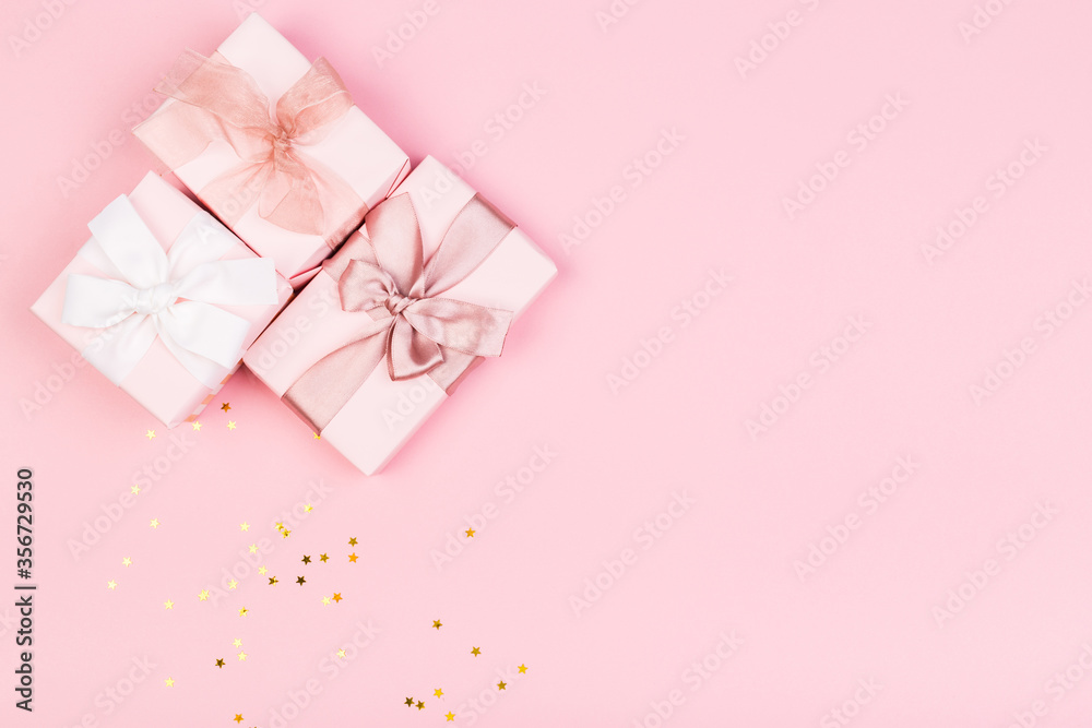 Gift or gift box and stars confetti on a pink table from above. Flat composition for birthday Gift or gift box and stars confetti on a pink table from above. Flat composition for birthday
