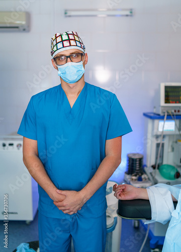 Portrait of a doctor or medical specialist. Vertical photo. Man in scrubs. Hospital background. Male doctor at hospital. Closeup.