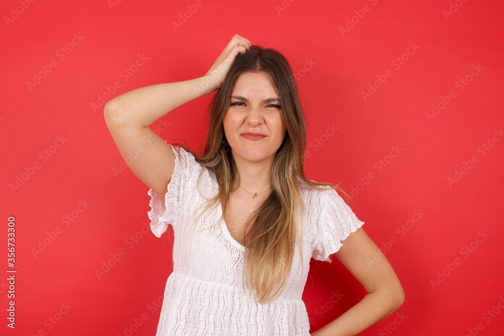Oops, what did I do? Beautiful blonde woman holding hand on head with frightened and regret expression. Wearing casual clothes standing against gray background. Oops, what did I do? Beautiful blonde woman holding hand on head with frightened and regret expression. Wearing casual clothes standing against gray background.