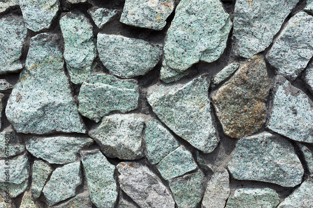 Fototapeta premium a fragment of a gray-blue stone wall for the background or texture.