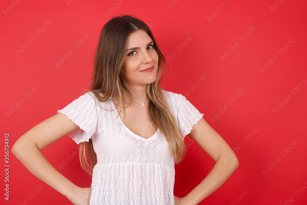 Funny beautiful young woman with fashionable haircut holding hands on waist and silly looking at awkward situation. Funny beautiful young woman with fashionable haircut holding hands on waist and silly looking at awkward situation.