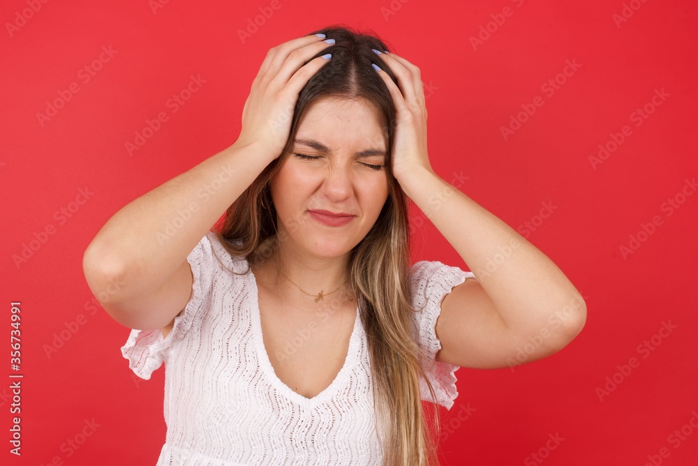 Young beautiful woman holding her head over isolated background suffering from headache desperate and stressed because pain and migraine. Hands on head. Young beautiful woman holding her head over isolated background suffering from headache desperate and stressed because pain and migraine. Hands on head.