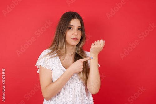 Beautiful young Caucasian woman over isolated background In hurry pointing to watch time, impatience, upset and angry for deadline delay