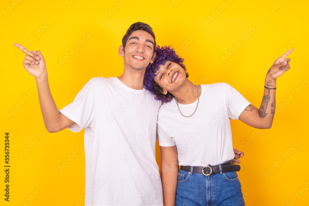 young couple of man and woman pointing isolated on color background young couple of man and woman pointing isolated on color background