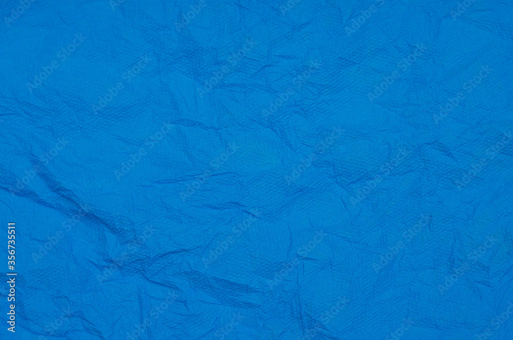 Fototapeta premium Rumpled embossed closeup napkin texture. Classic blue background